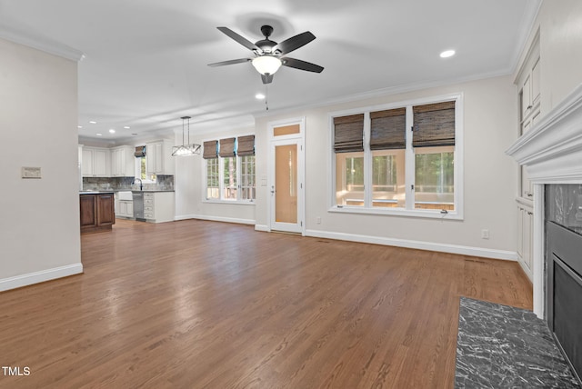 105 Bathgate Ln, Cary, NC 27513 - unfurnished living room with recessed lighting, ceiling fan, a fireplace with flush hearth, ornamental molding, and wood finished floors