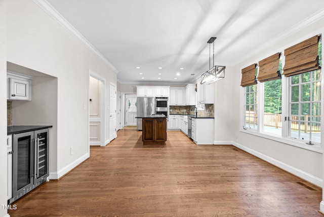 105 Bathgate Ln, Cary, NC 27513 - kitchen with wine cooler, stainless steel appliances, ornamental molding, a center island, and dark countertops