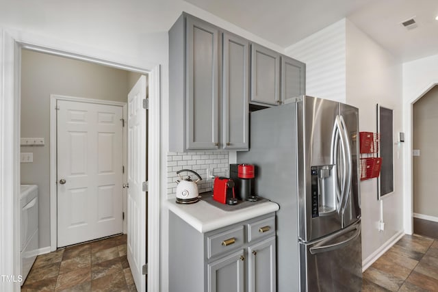8205 Rolling Glenn Dr, Raleigh, NC 27616 - kitchen featuring stainless steel refrigerator with ice dispenser, gray cabinets, stone finish floors, and light countertops