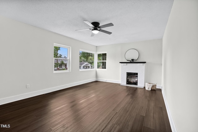 208 Fairview Ave SW, Wilson, NC 27893 - unfurnished living room with a textured ceiling, a fireplace, dark wood finished floors, and a ceiling fan