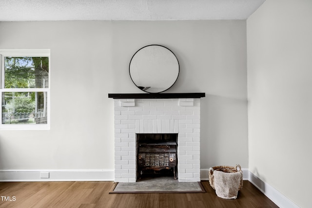 208 Fairview Ave SW, Wilson, NC 27893 - detailed view of wood finished floors, a fireplace, and a textured ceiling