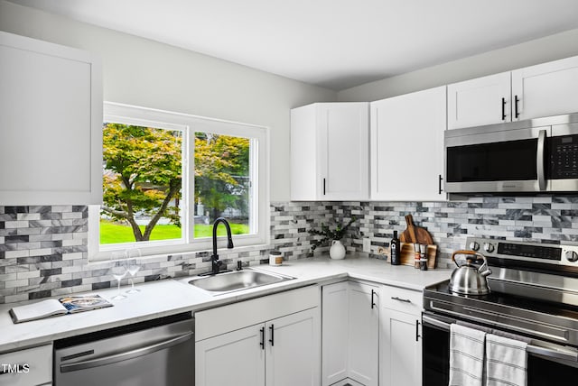 208 Fairview Ave SW, Wilson, NC 27893 - kitchen featuring appliances with stainless steel finishes, white cabinets, and tasteful backsplash