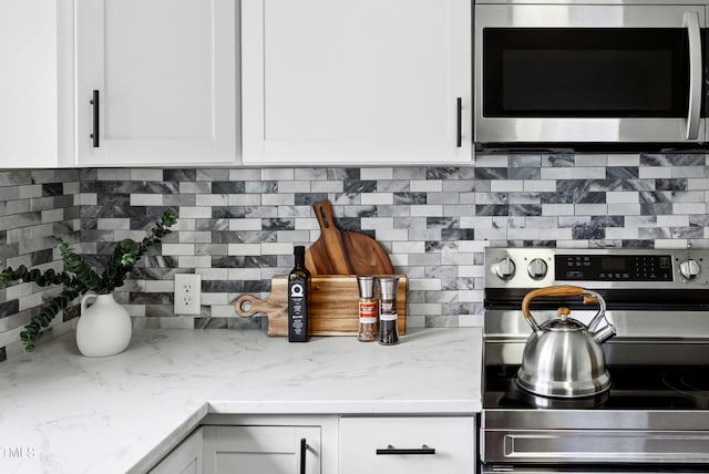 208 Fairview Ave SW, Wilson, NC 27893 - kitchen with appliances with stainless steel finishes, white cabinets, and backsplash