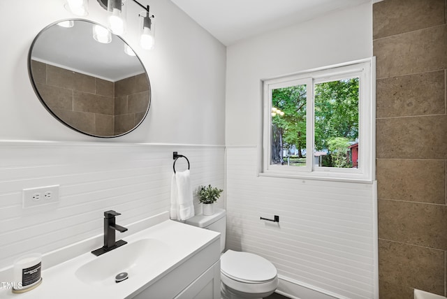 208 Fairview Ave SW, Wilson, NC 27893 - bathroom with tile walls, vanity, and a wainscoted wall