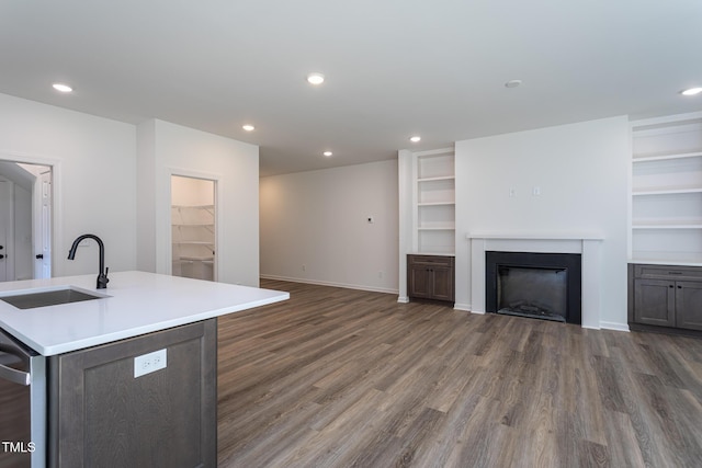 6069 Jones Cir, Sanford, NC 27332 - kitchen featuring wood finished floors, recessed lighting, light countertops, a fireplace, and a center island with sink