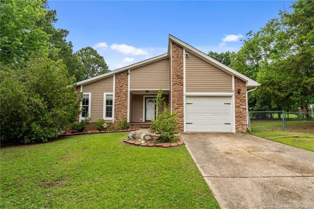 6305 Stoney Point Loop, Fayetteville, NC 28306 - mid-century inspired home featuring stone siding, driveway, and a garage