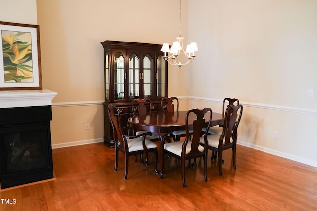 3423 Van Hessen Dr, Raleigh, NC 27614 - dining space featuring a chandelier, wood finished floors, and a fireplace