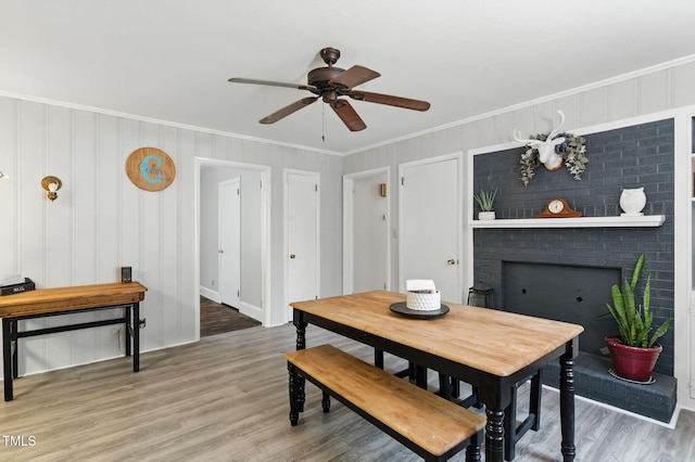 1015 S 1st St, Smithfield, NC 27577 - dining room with crown molding, wood finished floors, ceiling fan, and a brick fireplace