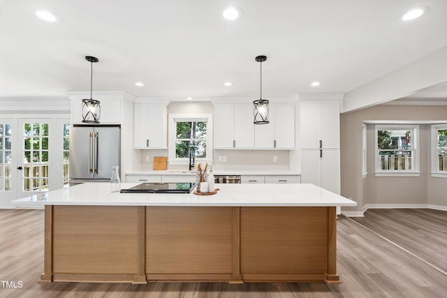 1609 Falls Ct, Raleigh, NC 27615 - kitchen with high end fridge, a large island, light countertops, light wood-style floors, and white cabinetry