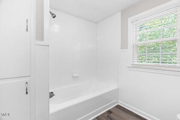 509 S Mckay Ave, Dunn, NC 28334 - bathroom featuring wood finished floors and washtub / shower combination
