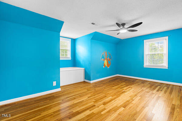 509 S Mckay Ave, Dunn, NC 28334 - empty room featuring vaulted ceiling, wood finished floors, ceiling fan, and healthy amount of natural light