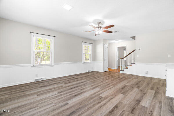 509 S Mckay Ave, Dunn, NC 28334 - unfurnished living room featuring stairs, ceiling fan, and wood finished floors