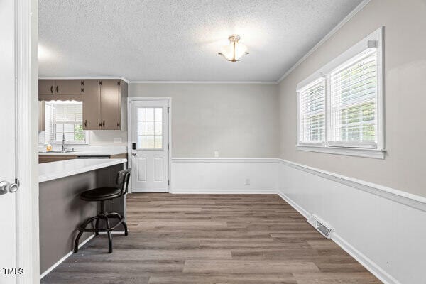 509 S Mckay Ave, Dunn, NC 28334 - unfurnished dining area with ornamental molding, a textured ceiling, and wood finished floors