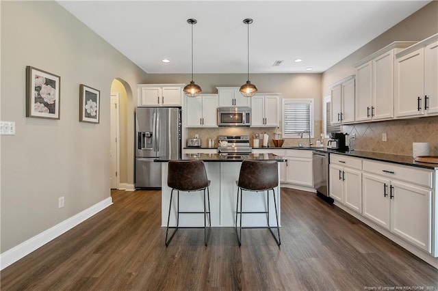 123 Sorrel Ct, Raeford, NC 28376 - kitchen featuring stainless steel appliances, arched walkways, dark countertops, a kitchen bar, and recessed lighting