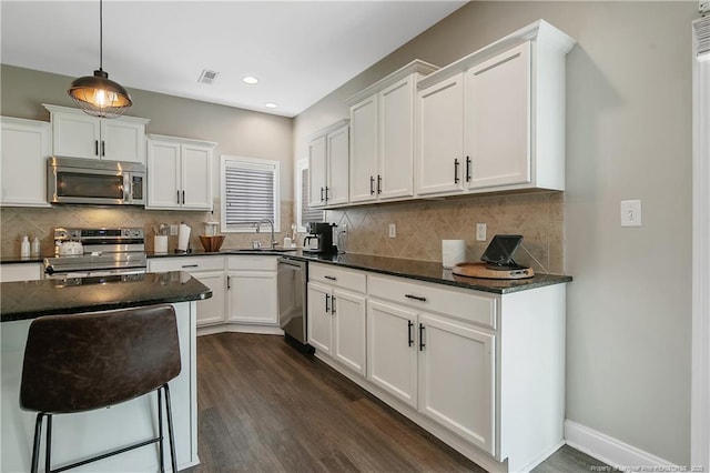 123 Sorrel Ct, Raeford, NC 28376 - kitchen featuring appliances with stainless steel finishes, white cabinetry, dark wood-type flooring, backsplash, and recessed lighting