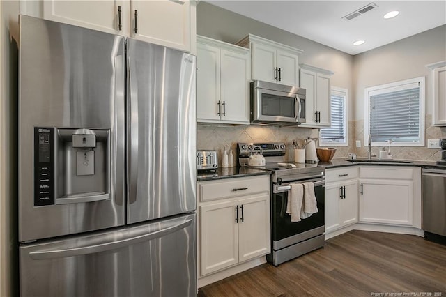 123 Sorrel Ct, Raeford, NC 28376 - kitchen with appliances with stainless steel finishes, white cabinetry, dark wood-style flooring, tasteful backsplash, and recessed lighting