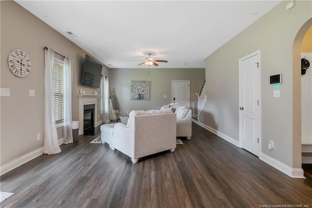 123 Sorrel Ct, Raeford, NC 28376 - living area featuring arched walkways, a ceiling fan, dark wood-type flooring, and a glass covered fireplace