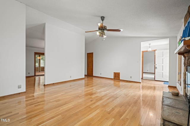 601 Wofford Rd, Durham, NC 27707 - unfurnished living room featuring a stone fireplace, light wood-type flooring, ceiling fan, and vaulted ceiling