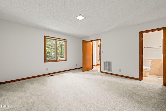 601 Wofford Rd, Durham, NC 27707 - unfurnished bedroom with a textured ceiling, light carpet, and connected bathroom