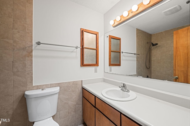 601 Wofford Rd, Durham, NC 27707 - full bathroom featuring vanity, tiled shower, a textured ceiling, and tile walls