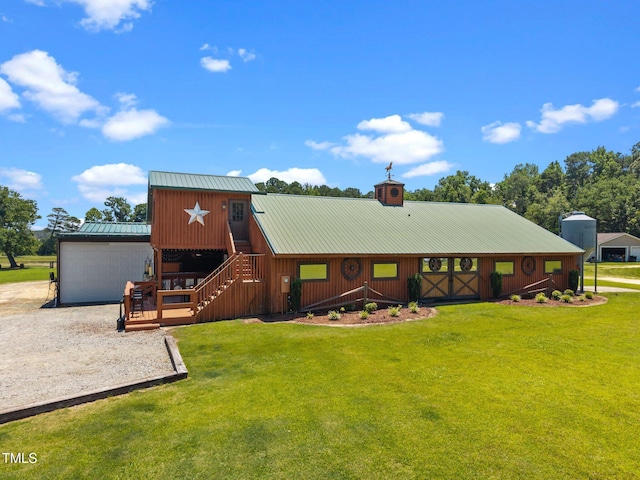 view of front of house featuring a metal roof, a front yard, a chimney, and gravel driveway