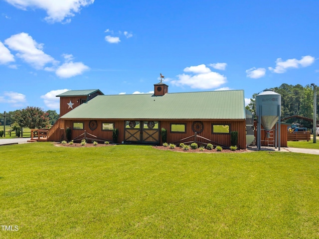 back of house featuring a lawn, a metal roof, and a chimney