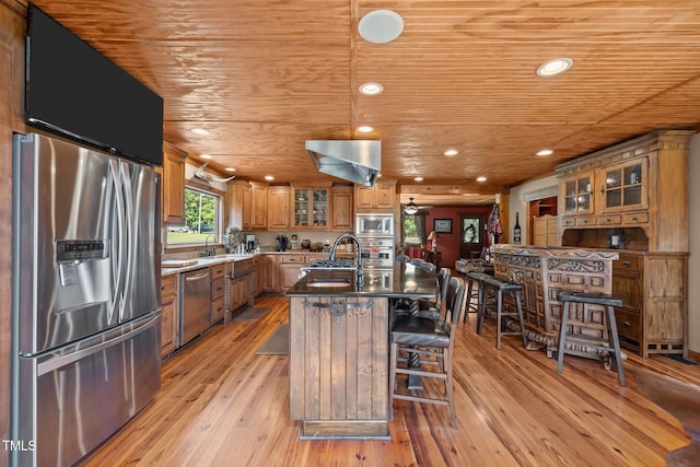 kitchen featuring appliances with stainless steel finishes, wood ceiling, brown cabinetry, light wood-style flooring, and glass insert cabinets