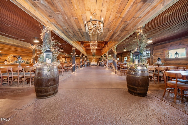dining area featuring a chandelier, wood walls, and wood ceiling