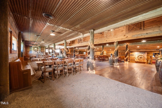 carpeted dining space with wood walls