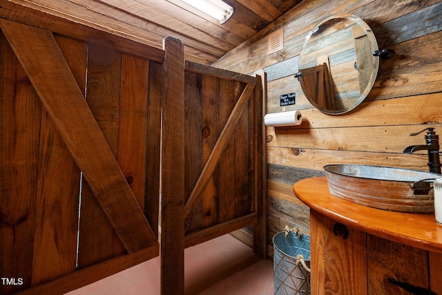 bathroom featuring wooden walls, wooden ceiling, and vanity