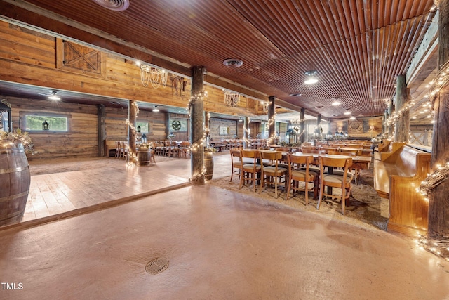 miscellaneous room featuring wooden walls and finished concrete flooring