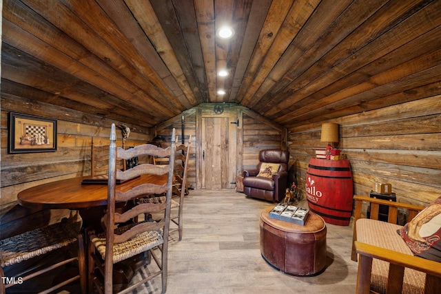 living area with lofted ceiling, wood walls, wood-type flooring, and wooden ceiling