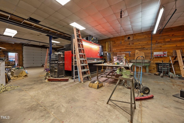 garage with a workshop area and wooden walls