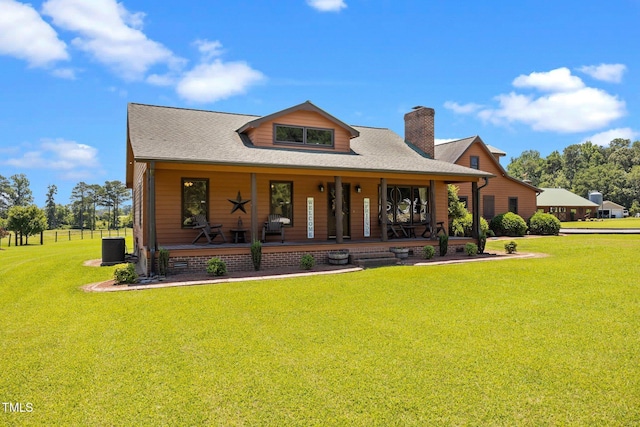 view of front of property with a porch, a front yard, a chimney, and a shingled roof