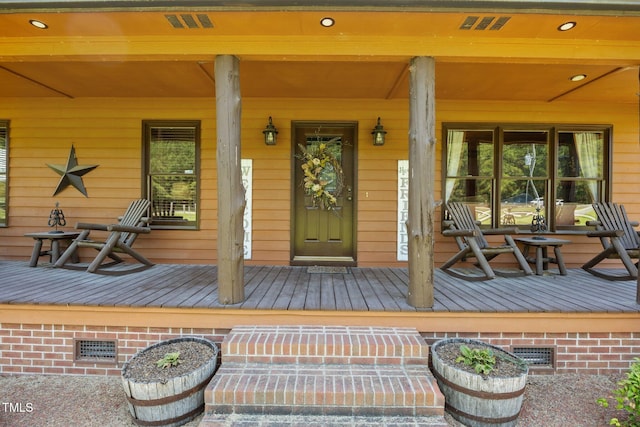 view of exterior entry featuring a porch and crawl space