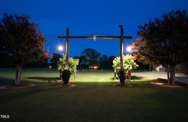 yard at twilight featuring a yard