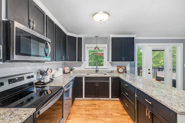5900 Holly Dr, Raleigh, NC 27616 - kitchen featuring appliances with stainless steel finishes, a peninsula, plenty of natural light, light stone counters, and crown molding