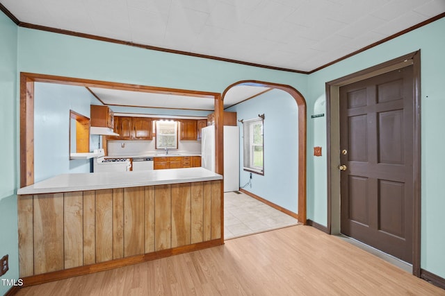 7595 Clayton Blvd Unit B, Clayton, NC 27520 - kitchen featuring white appliances, light countertops, ornamental molding, light wood-style floors, and a peninsula