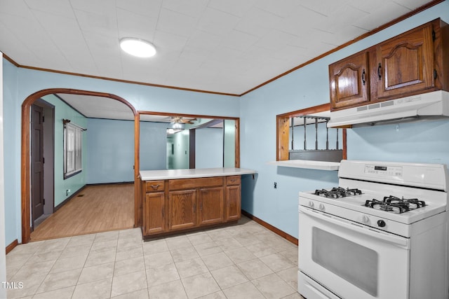 7595 Clayton Blvd Unit B, Clayton, NC 27520 - kitchen featuring gas range gas stove, under cabinet range hood, crown molding, arched walkways, and brown cabinets
