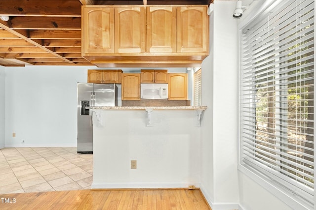 18 Frances St, Chapel Hill, NC 27517 - kitchen featuring white microwave, stainless steel fridge with ice dispenser, a breakfast bar area, light brown cabinetry, and a peninsula
