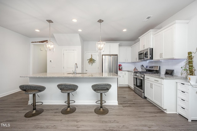 321 Conrad Ln, Wake Forest, NC 27587 - kitchen featuring stainless steel appliances, a kitchen breakfast bar, an island with sink, white cabinets, and recessed lighting