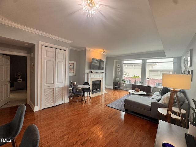 510 Glenwood Ave Unit 606, Raleigh, NC 27603 - living room featuring a fireplace with flush hearth, wood finished floors, a chandelier, and ornamental molding