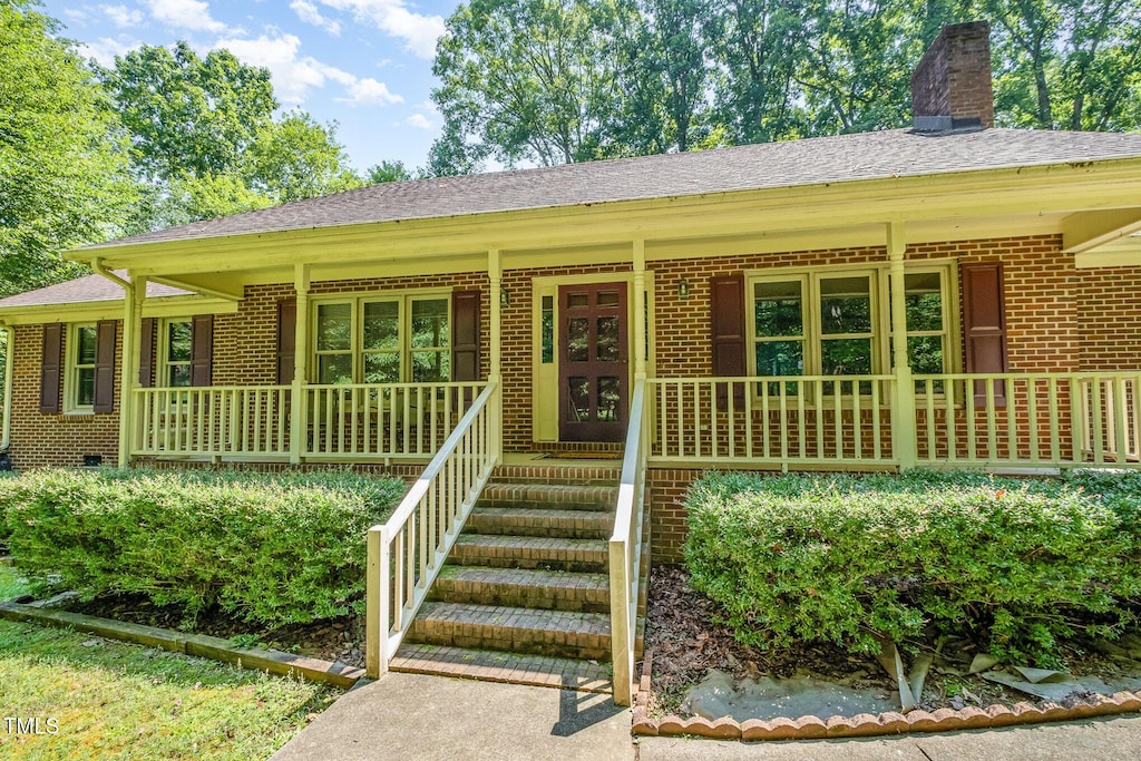 9005 Bahama Woods Ln, Bahama, NC 27503 - single story home with brick siding, covered porch, a chimney, and a shingled roof