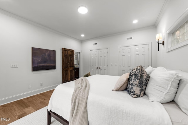 807 Edmund St, Raleigh, NC 27604 - bedroom with multiple closets, wood finished floors, crown molding, and recessed lighting