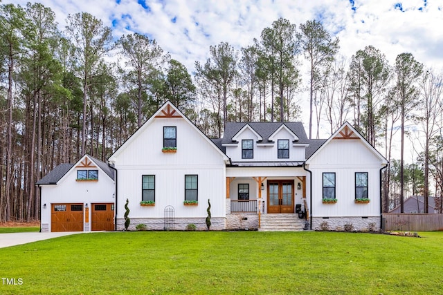 257 Rawhide Dr, Louisburg, NC 27549 - modern farmhouse featuring covered porch, a metal roof, a garage, a standing seam roof, and driveway