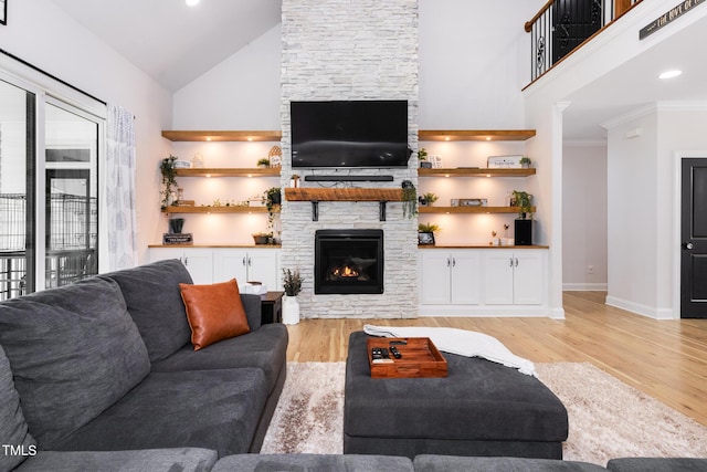 257 Rawhide Dr, Louisburg, NC 27549 - living room with a stone fireplace, high vaulted ceiling, light wood-type flooring, and crown molding