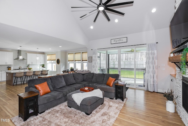 257 Rawhide Dr, Louisburg, NC 27549 - living area with a ceiling fan, high vaulted ceiling, a fireplace, light wood-style flooring, and recessed lighting