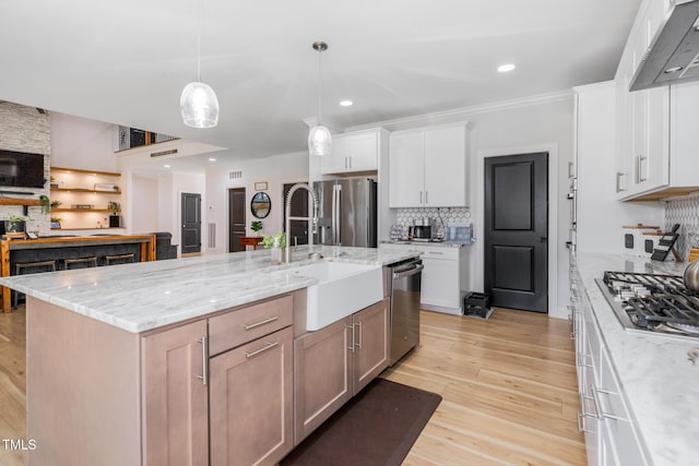 257 Rawhide Dr, Louisburg, NC 27549 - kitchen featuring stainless steel appliances, tasteful backsplash, white cabinetry, light wood-style flooring, and crown molding