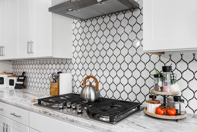 257 Rawhide Dr, Louisburg, NC 27549 - kitchen featuring stainless steel gas stovetop, extractor fan, white cabinets, and decorative backsplash