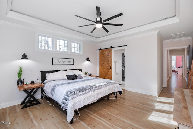 257 Rawhide Dr, Louisburg, NC 27549 - bedroom with a barn door, a raised ceiling, crown molding, multiple windows, and light wood-style floors